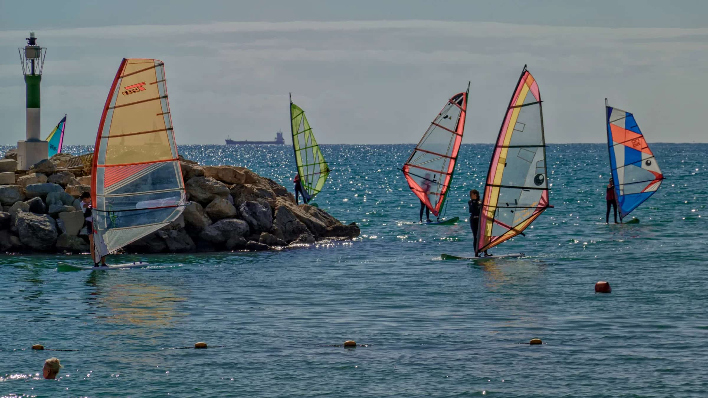Suda birlikte pratik yapan küçük windsurf grubu