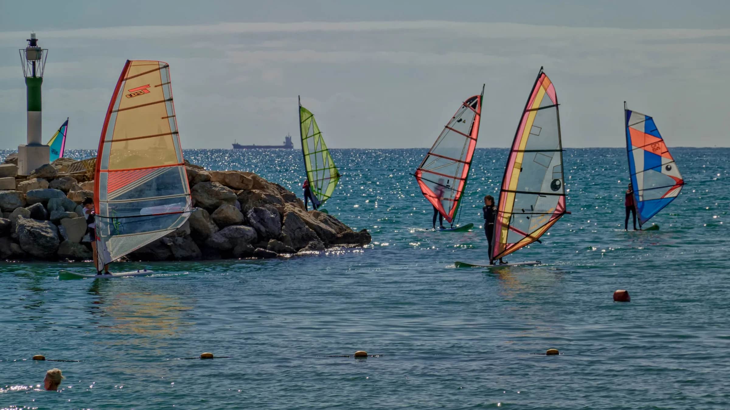 Suda birlikte pratik yapan windsurf grubu